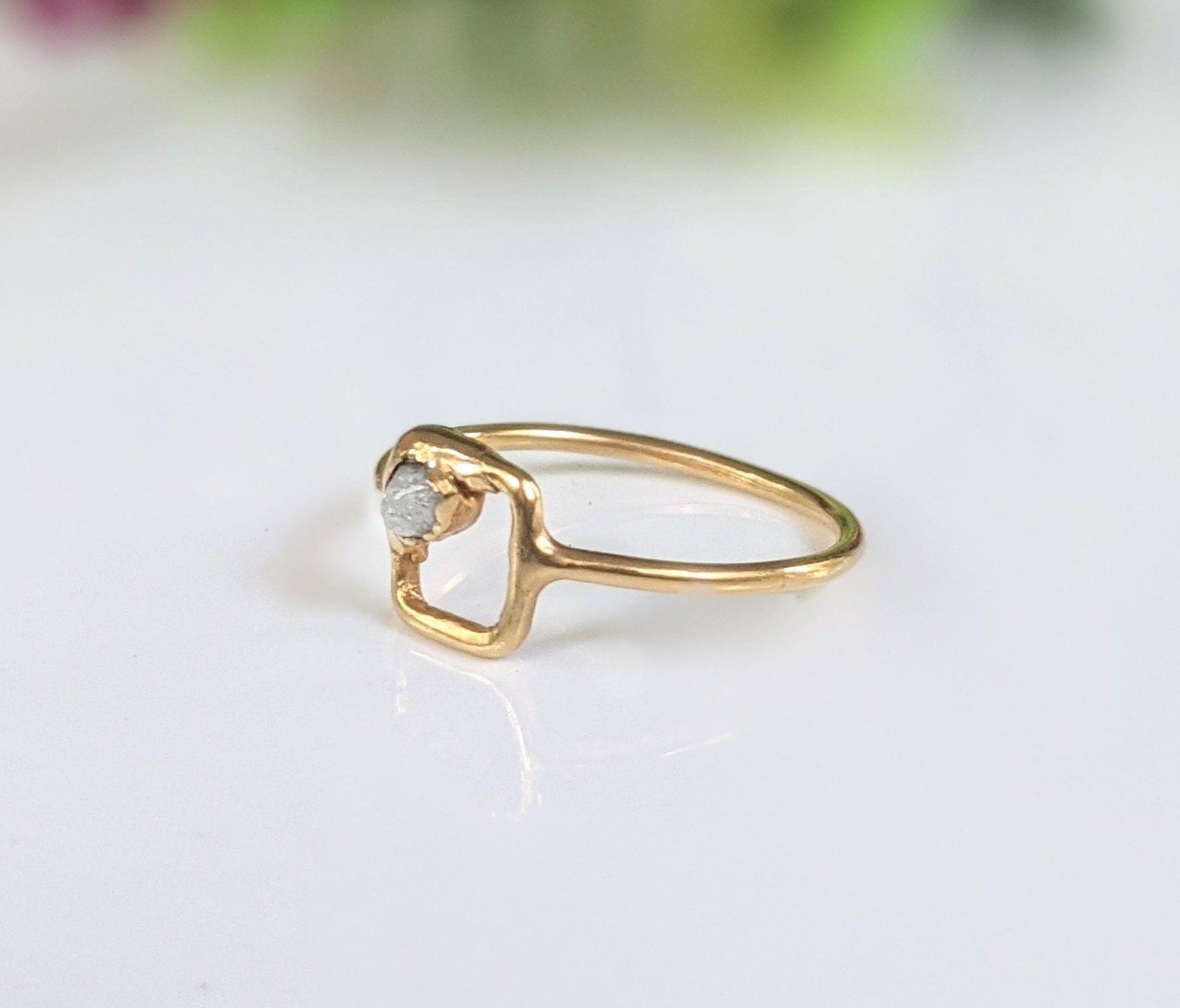Solid gold minimalist square ring featuring a raw conflict-free diamond on 14k gold band, showcasing unique geometric design.