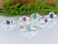 Solid silver aquamarine ring with trilliant gem, showcased among other colorful gemstone rings.