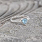 Solid Silver Aquamarine ring with trilliant cut, featuring an organic textured band, symbolizing love and individuality.