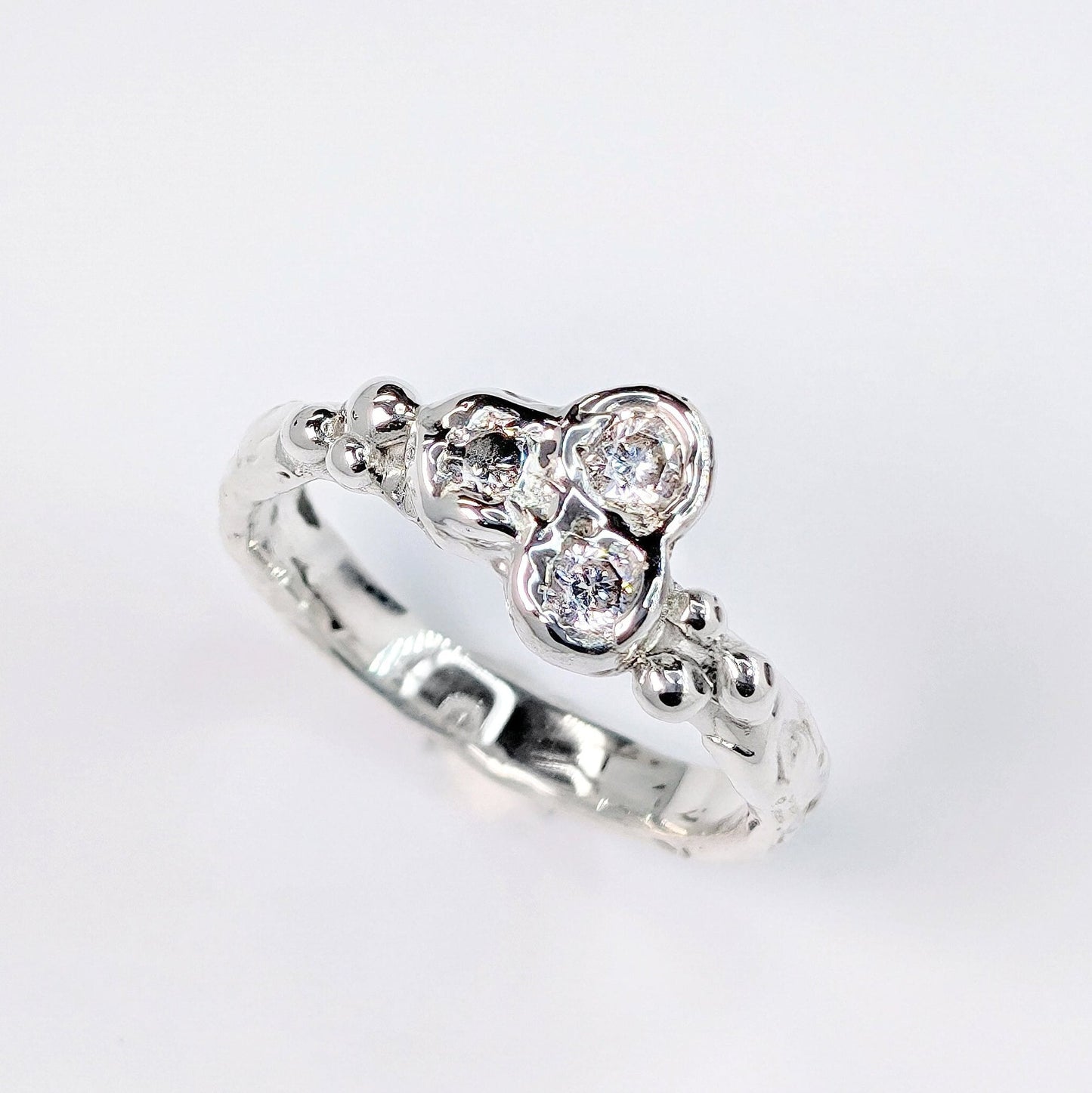 Silver CZ Cluster ring featuring three sparkling cubic zirconia stones in an organic molten band design.
